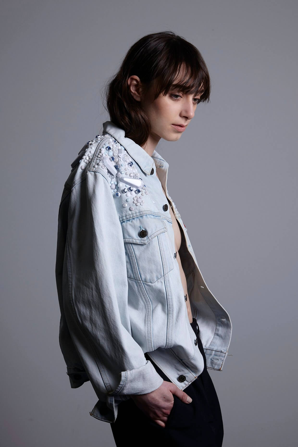 A person wearing the XS '100 Dinge' film sample of the Pinball Jacket, showing a more tailored Western-style fit compared to the oversized bomber version, while maintaining the same intricate hand-beaded detailing.