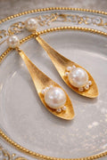 Vorderansicht der vergoldeten „The Spoon“ Ohrringe mit großen, weißen 11-12 mm Barockperlen und winzigen Baby-Perlen.