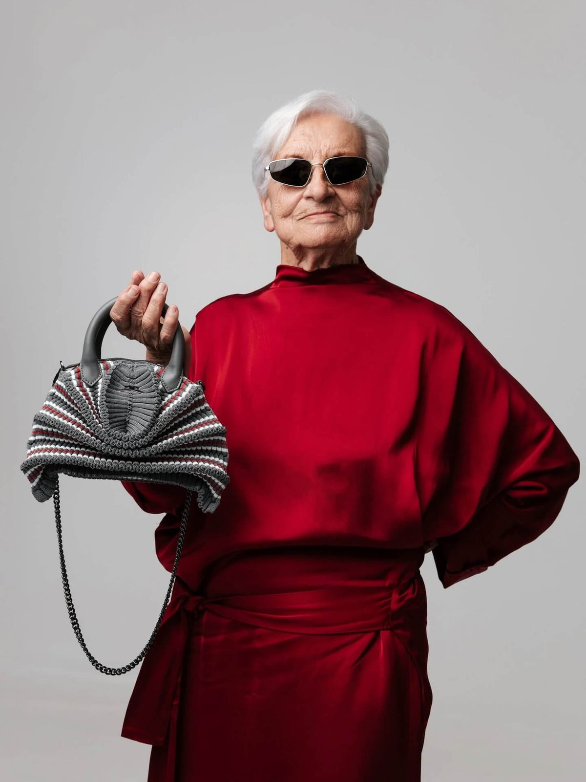 Model trägt die gestrickte Balom Attesa Leder Handtasche mit Kette in Gran Turismo bei NOUS Studio